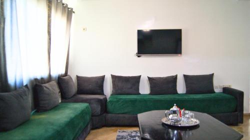 a living room with a couch and a flat screen tv at City Center Stay - Résidence Omar 1 by ZenStay in Fès