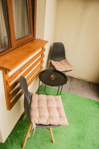 two chairs and a table on a balcony with green carpet at Hotel Graif Ti in Tbilisi City