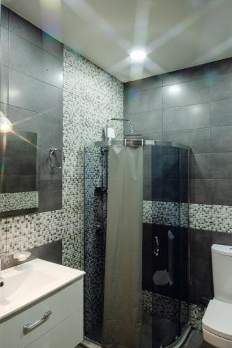 a bathroom with a shower and a toilet and a sink at Hotel Graif Ti in Tbilisi City