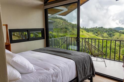 a bedroom with a bed and a balcony with a view at BiBO Casa Savia in Monteverde Costa Rica