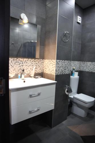 a bathroom with a sink and a toilet and a mirror at Hotel Graif Ti in Tbilisi City
