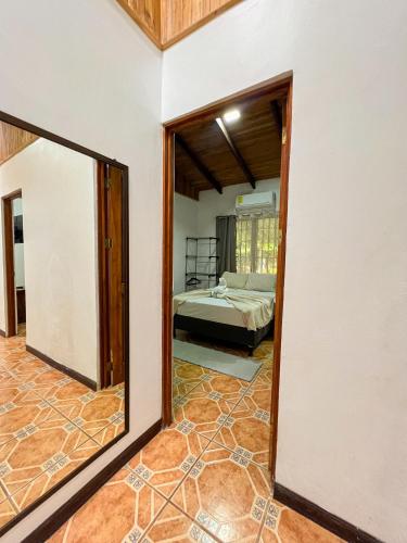 a mirror in a room with a bed and a bedroom at La Casa de Piedra in Puerto Jiménez