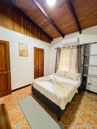 a bedroom with a bed in a room with wooden ceilings at La Casa de Piedra in Puerto Jiménez