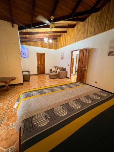 a bedroom with a large bed and a couch at La Casa de Piedra in Puerto Jiménez