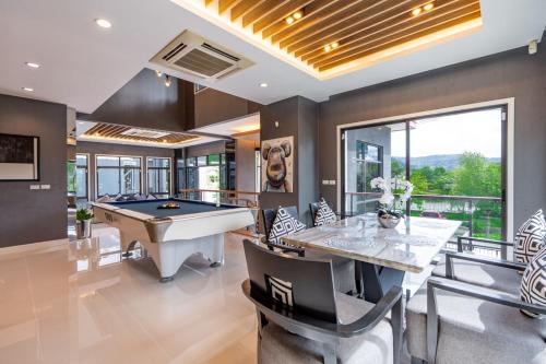 una sala da pranzo con tavolo da biliardo e tavolo da biliardo di The Golden Palm Residence - Kathu - 10 min to Patong Beach a Ban Thung Thong