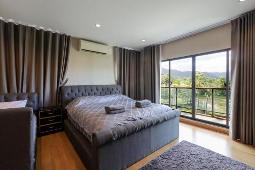 una camera da letto con un letto e una grande finestra di The Golden Palm Residence - Kathu - 10 min to Patong Beach a Ban Thung Thong