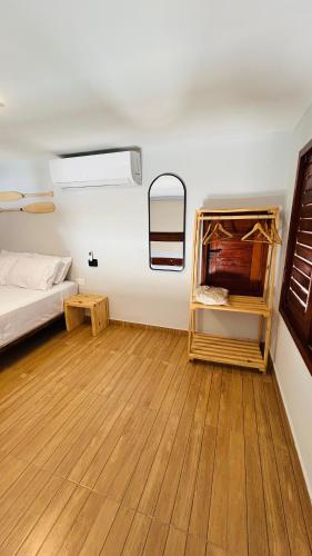 a room with a bed and a wooden floor at Mar e Terra Bangalôs in Areia Branca