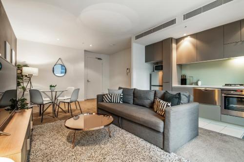 a living room with a couch and a table at Spacious City Fringe RetreatPool & Free Parking in Melbourne