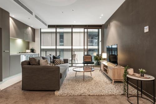 a living room with a couch and a table at Spacious City Fringe RetreatPool & Free Parking in Melbourne