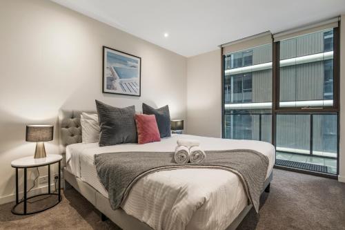 a bedroom with a large bed and a window at Spacious City Fringe RetreatPool & Free Parking in Melbourne