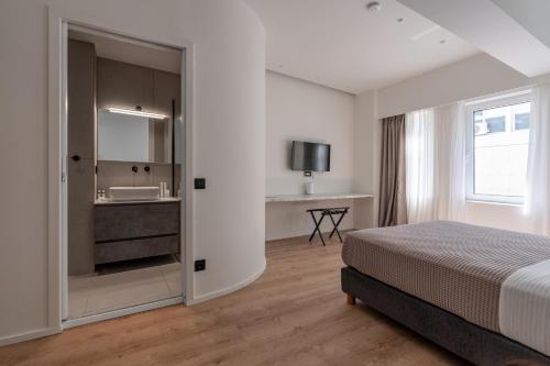 une chambre d'hôtel avec un lit et un lavabo dans l'établissement ERMOU 40 SUITES, à Athènes