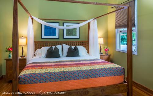 a bedroom with a large bed with a canopy at Ka'awa Loa Plantation in Captain Cook
