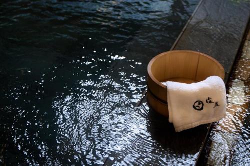 a bucket sitting on the side of a body of water at Yumura Onsen MIDORIYA in Shinonsen
