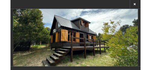 a wooden house sitting on a pile of logs at Cabanas Gael in Mar de las Pampas