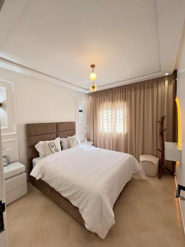 a bedroom with a large bed and a window at Dream apartment in Meknès