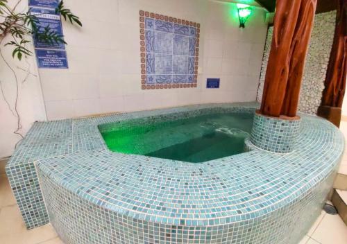 a swimming pool with a tiled tub in a room at Hotel Casa Branca in Guarujá