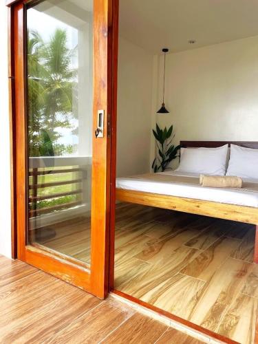 a mirror in a room with a bed and a window at Appartment Bonak peaceful Beachfront Escape with Kitchen and AC in General Luna
