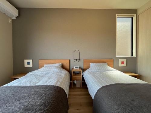 two beds sitting next to each other in a bedroom at konoma - Vacation STAY 99101v in Takashima