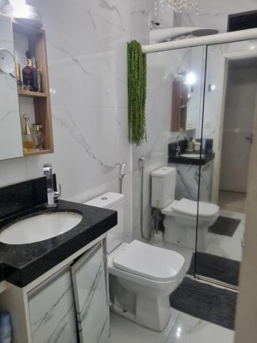 ein weißes Badezimmer mit Toilette und Waschbecken in der Unterkunft Apto 2 quartos reformado centro in Cuiabá
