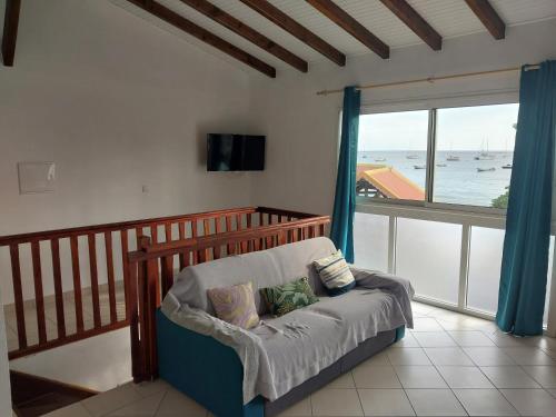 a living room with a chair and a large window at Tiatia T3 in Les Anses-dʼArlets