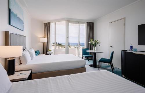 a hotel room with two beds and a view of the ocean at Rendezvous Hotel Perth Scarborough in Perth