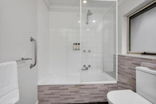 a bathroom with a shower and a toilet at Elphin Serviced Apartments in Launceston