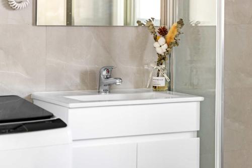ein Badezimmer mit einem weißen Waschbecken und einem Spiegel in der Unterkunft Bright Detached Single Room - Near Top Ryde City Shared Amenities in Sydney