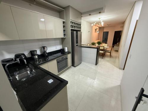 a large kitchen with white cabinets and a dining room at Paraíso do Oeste in Luis Eduardo Magalhaes