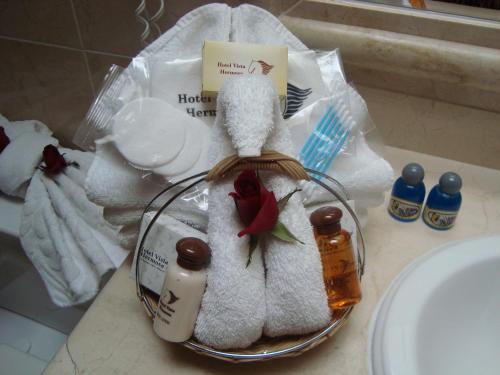 a basket of towels and other items on a bathroom counter at Hotel Vista Hermosa in Cuernavaca