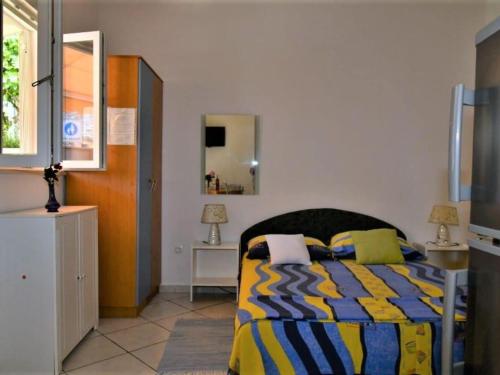 a bedroom with a bed with a yellow and blue comforter at Studio Apartment in Supetar