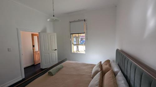 ein Schlafzimmer mit einem Bett und einem Fenster in der Unterkunft Little Yellow Guesthouse in Melbourne