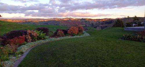 a garden with a path in the mountains at sunset at Countryside Comforts in Taumarunui