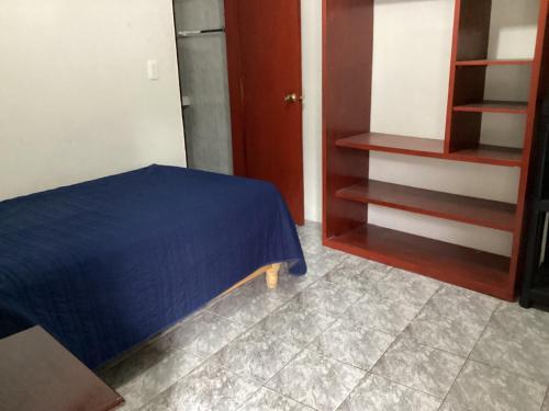 a bedroom with a blue bed and a closet at Habitación privada zona Satélite in Mexico City
