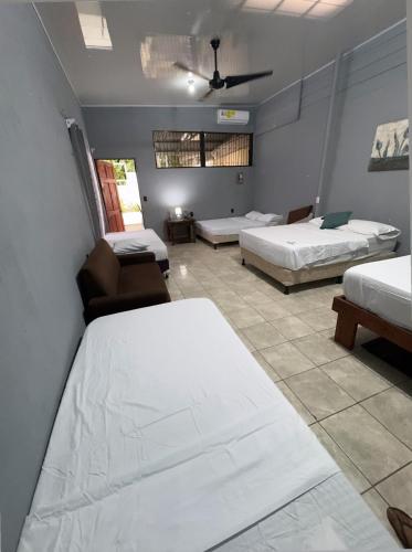 a hotel room with two beds and a couch at Casa Pelíkano Uvita in Uvita