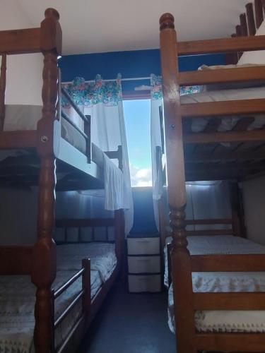 a bedroom with two bunk beds and a window at hostel Boa Onda Trindade in Paraty