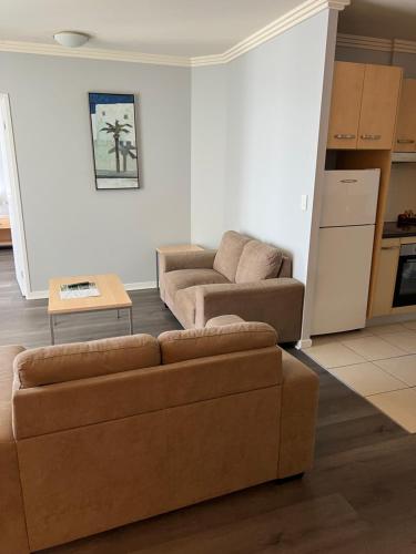 a living room with a couch and a table at Caloundra Central Apartment Hotel Official in Caloundra