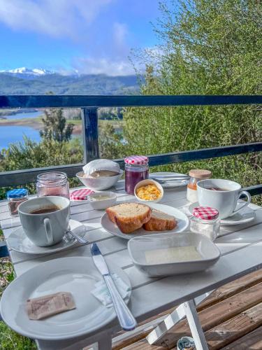 a table topped with plates of food and cups of coffee at ECOREFUGIO SPA in Colbún Alto