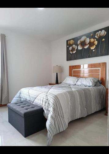 a bedroom with a large bed with a bench next to it at Cabañas el Rincon de los Sueños in Las Vigas