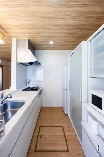 a kitchen with a sink and a refrigerator at AMP FLAT Baika in Dazaifu