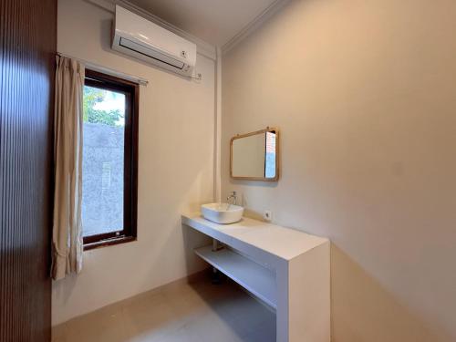 SempidiにあるModern Studio with Pool Between Canggu and Ubudの洗面台と鏡と窓のあるバスルーム