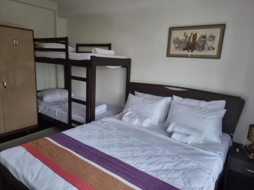 a bedroom with a bed and two bunk beds at Villa Omaru Mountain Views Kandy Hanthana in Kandy
