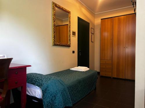 a bedroom with a bed and a dresser and a mirror at Da Mariuccia in Robecchetto con Induno
