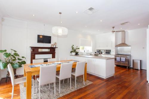 a kitchen and dining room with a wooden table and chairs at Sunset Serenity in Scarborough in Perth