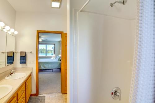 a bathroom with a sink and a shower and a bedroom at Live Large on Saddle Lake! Family Home with Dock in Grand Junction