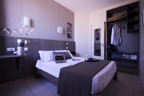 a bedroom with a bed with a black and white sheets at Le Strasbourg Hotel in Montpellier