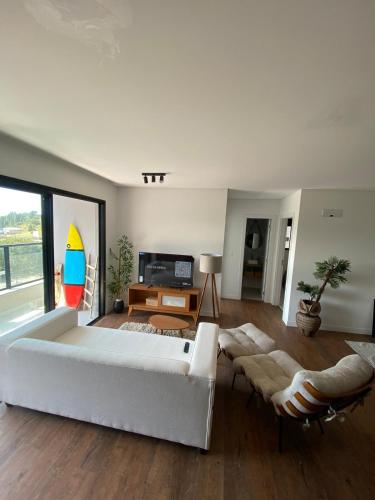 a living room with a white couch and a table at Ap na Brava in Itajaí