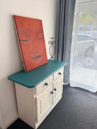 a painting on top of a cabinet in a room at Coffs Windmill Motel in Coffs Harbour