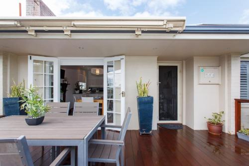 a dining room with a table and chairs on a patio at Sunset Serenity in Scarborough in Perth