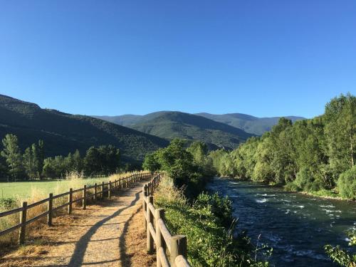 a fence next to a river with mountains in the background at Camping Noguera Pallaresa in Sort