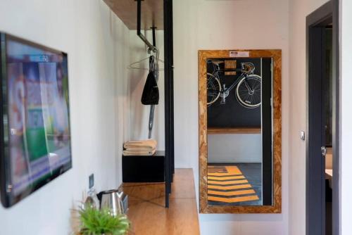 a mirror in a hallway with a bike in it at The VELO'S Hotel and Pumptrack in Aranyaprathet